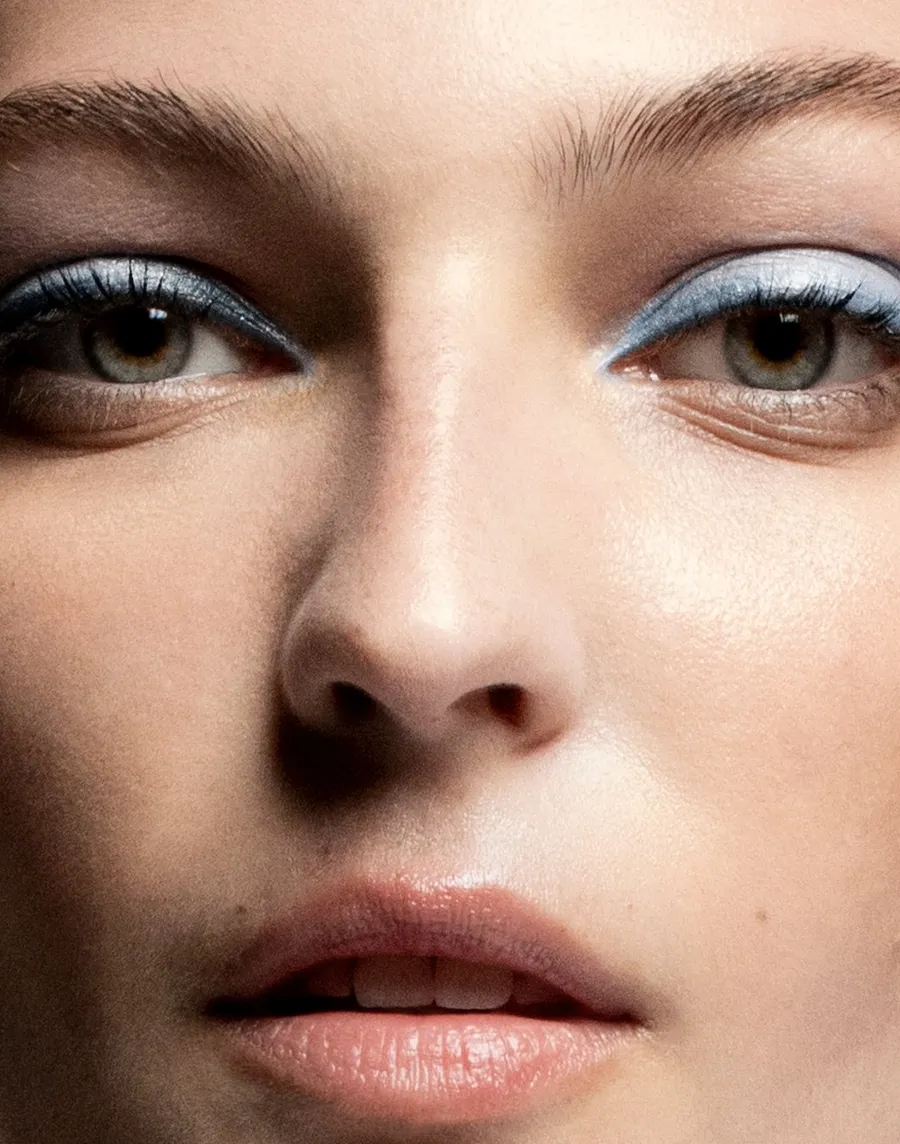 Beauty close-up: a model’s eyes with pale blue liner and dewy skin